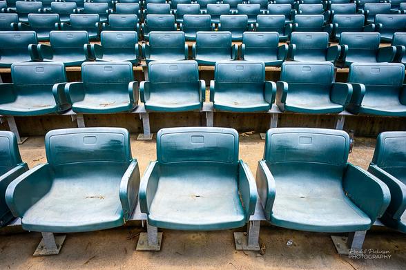 Rows of green plastic chairs in an outdoor amphitheater.