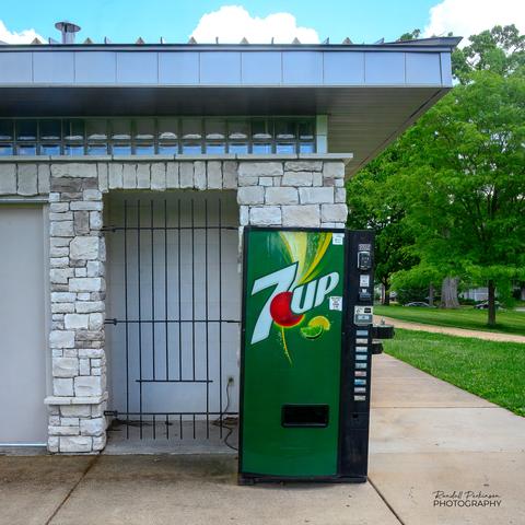 A soda vending machine appears to have "escaped" from its intended location behind steel bars.