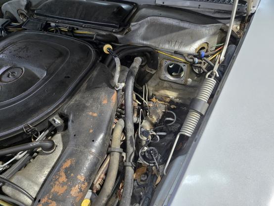 An image of the under hood of a car. A hole in the firewall is visible where a brake booster and master cylinder would be installed.