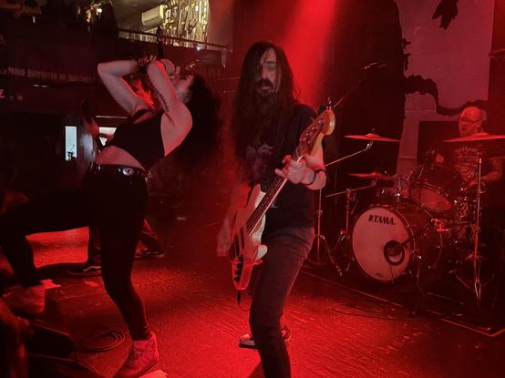 Three of the five band members – it was tough to keep them all in frame! Female singer striking dramatic, head back, leg up on monitor pose, bass player looking like a bass player.