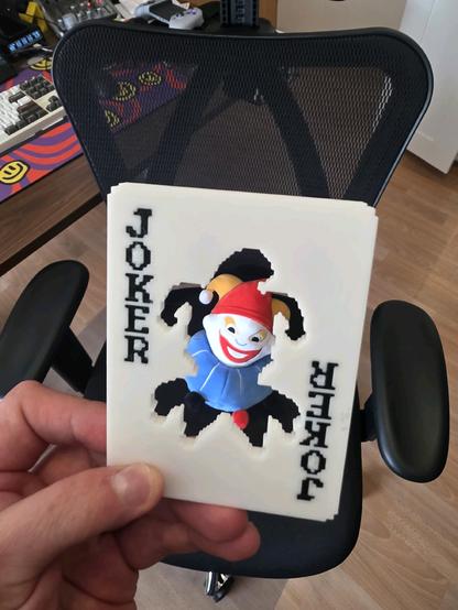 same joker stencil 3d print, but there is a jimbo (balatro mascot) plushie behind the stencil