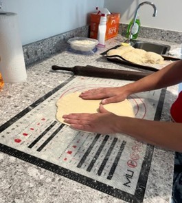 Preparing pizza dough by hand.