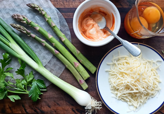Auf dem Brett 2 Blätter Reispapier, Petersilie Frühlingszwiebel 3 Stangen Gründer Spargel, geriebener Käse, ein Glas mit 2 aufgeschlagenen Eiern, eine Schale mit Mayonnaise + Chilisauce