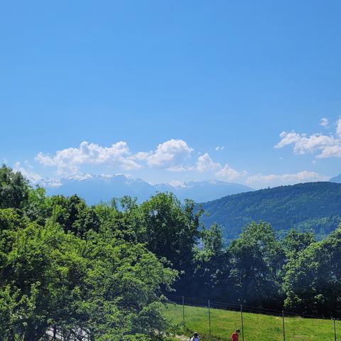 Mehr Bäume Berge und Wolken vor blauem Himmel