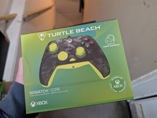 Green box showing the Turtle Beach Rematch Core Xbox Wired Game Controller. The controller itself has a black camoflage faceplate highlighted by green/yellow joysticks and directional pad.
