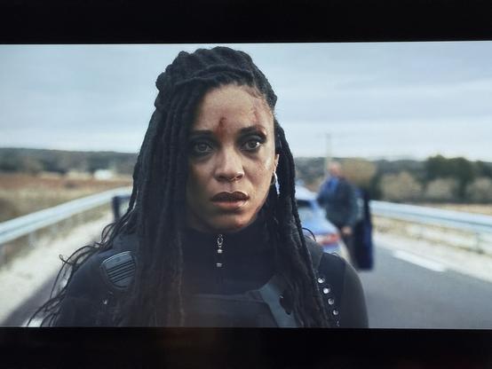 Stéfi Celma dans « Balle perdue 2 » : dreadlocks et combinaison élastomère moulante zippée jusque dans le cou sous son gilet par-balle. Difficile de dire si elle joue une policière Française ou un personnage de Cyberpunk 2077.