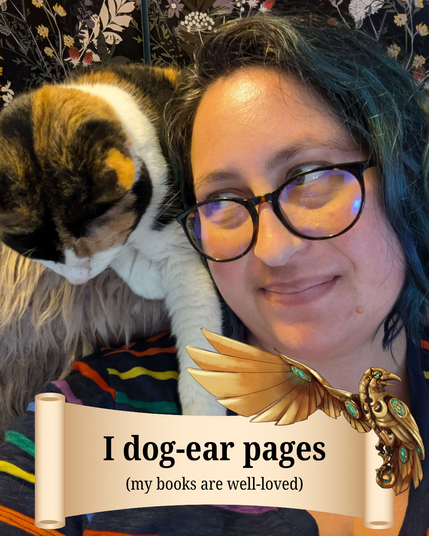 The picture is of a woman with blue hair and glasses with a cat on her shoulder. On the bottom of the image, there is a tan scroll with a golden raven on the top right corner of it. The text reads, “I dog-ear pages (my books are well-loved).”