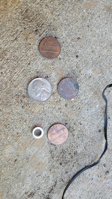 A dime and three pennies on a sidewalk