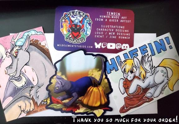 Photo of artwork being mailed out. A my little pony artist trading card size original of Discord, a magnet of a cornish rex kitten in a sweater in the autumn season next to a pumpkin, and a my little pont ATC print of Derpy Hooves eating a muffin.