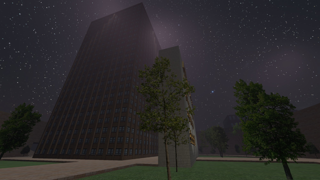 Night time view from the base of a tall brick building. To the right of the building stands a tiled structure with gold extruded 3D text that is unreadable from this angle.