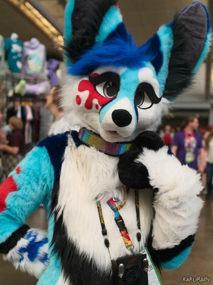Cyan Fennec fursuiter with white countershading and ink splatter marks