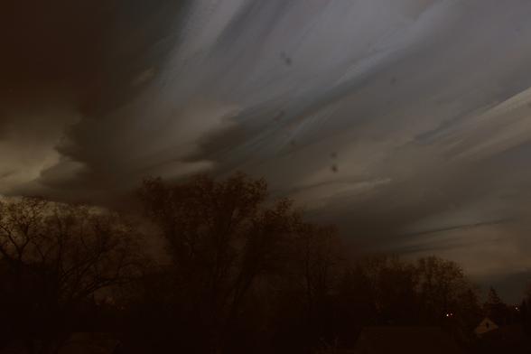The trees across the street from my house; above them, the clouds have weird striations, because this isn't a single photo but a stack of 300 5-second exposures taken during a brief thunderstorm on Sunday evening