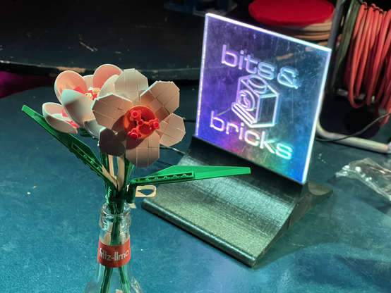 Klemmbausteinblumen vor Bits&Bricks-Schild