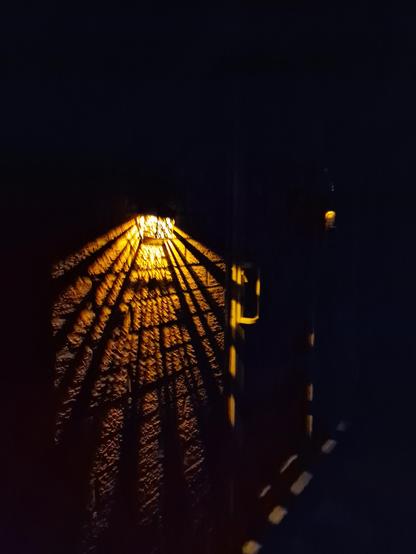 A light pattern thrown from an outside solar light at night.