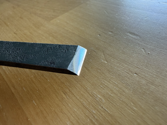 Close-up of the cutting edge. Light reflects on the mirror-polished bevel.