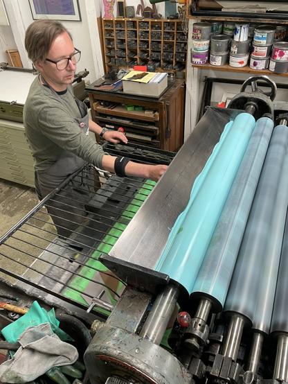 Es wird am Farbwerk der Druckpresse die Farbe eingestellt. Wir haben einen leichten Verlauf in Blau-Grün.