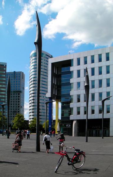 large square with modern high rise buildings and street lamps that look like huge dragon teeth.