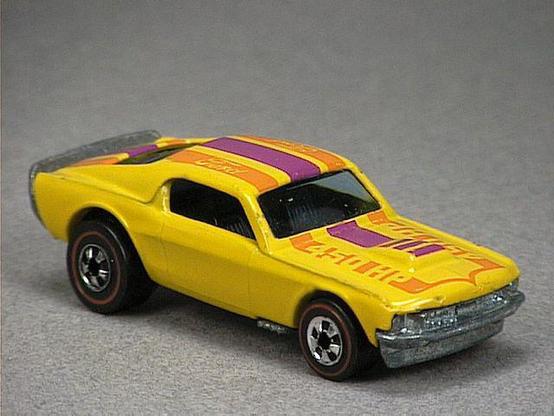 Released in 1975, Yellow Mustang Stocker of 1975 Hot Wheels with Redline wheels. Tampo: Blue and red 'Ford' on roof, '450 HP' on hood. Packaging: Flying Colors(tm). Metal Body, Metal Base. Made in Hong Kong. Scarcity: 8/10