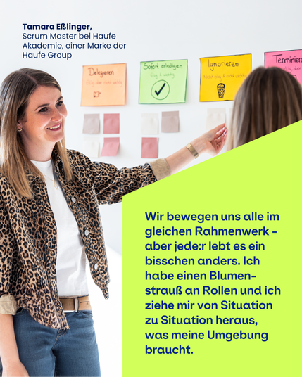 Bild mit zwei Mitarbeitenden, die Notizzettel an einer Wand besprechen. Zu sehen ist das Zitat: "Wir bewegen uns alle im gleichen Rahmenwerk - aber jede:r lebt es ein bisschen anders. Ich habe einen Blumenstrauß an Rollen und ich ziehe mir von Situation zu Situation heraus, was meine Umgebung braucht." Tamara Eßlinger, Scrum Master bei der Haufe Akademie, einer Marke der Haufe Group
