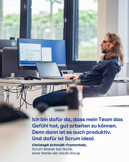 Ein Mitarbeitender sitzt am Schreibtisch vor seinem Laptop und einem großen Monitor im Büro. Zu sehen ist das Zitat: "Ich bin dafür da, dass mein Team das Gefühl hat, gut arbeiten zu können. Denn dann ist es auch produktiv. Und dafür ist Scrum ideal." Christoph Schmidt-Frommholz, Scrum Master bei Haufe, einer Marke der Haufe Group.