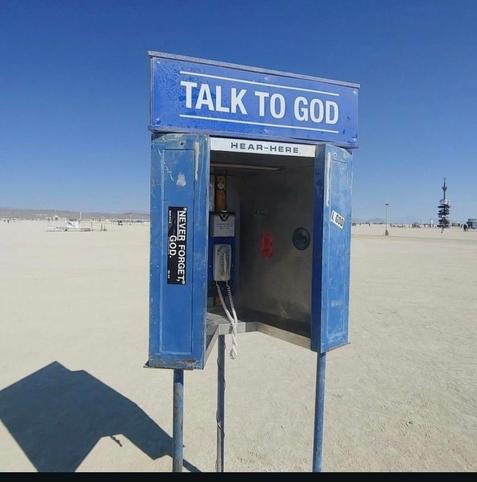 a phone booth in the desert that says: talk to god, hear-here
and sticker that say: i, god & never forget god