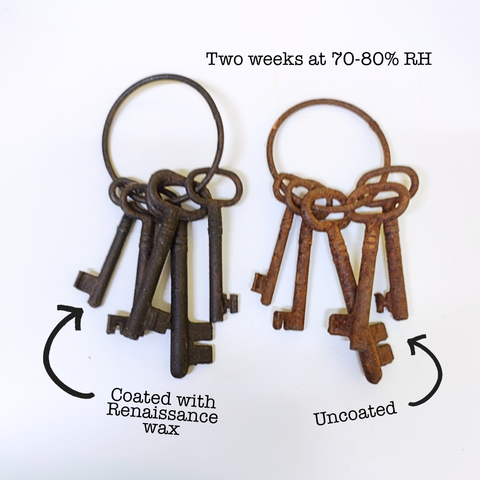 Two sets of old keys on large rings on a white table. The key bundle on the left is a dark grey-to-brown colour, while the bundle on the right is orange-to-brown.

Above them is some text: two weeks at 70-80% RH (relative humidity)

Below are arrows pointing to the different sets of keys: the dark one on the left reads "coated with Renaissance wax" and the rusted one on the right reads "uncoated"

In other words this is a nice example of what happens when iron is kept in a damp environment!