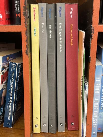 A colour photo of a portion of a front view of a little library in Toronto’s East End which features five large volumes, four of which are operatic scores by Richard Wagner in German, along with one by Ludwig van Beethoven.