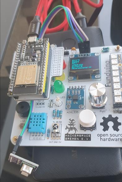 Es ist eine Platine zu sehen auf der ein Mikrocontroller, mehrere Sensoren, LEDs ein Display und Knöpfe sitzen