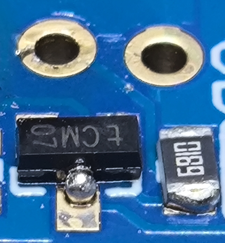 Close up  of a blue PCB on the left is a three legged SOT-23 component showing the side with a single leg which has solder balled around the leg but none on the pad. To the right is an 0805 681R resistor which also has the solder stuck to the ends but none on the PCB pads.

Above these are two plated holes surrounded by spent flux but there's no solder on the rings.