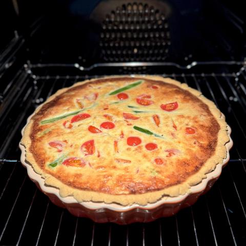 Eine Spargel Tarte mit Gorgonzola und Tomaten im Backofen