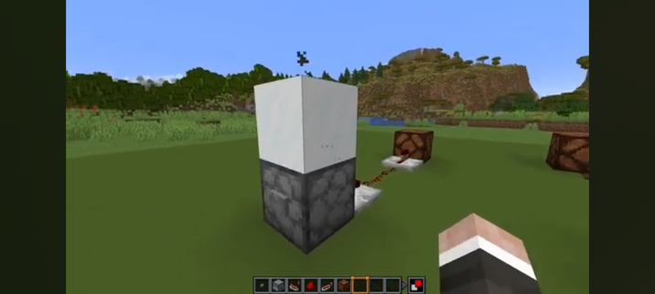 A dropper with a button pointed upwards with a block of powdered snow on it. With only the bucket in the dropper, the comparator only outputs a signal level of 1 instead of 2 when the powdered snow is sucked back into the dropper and bucket on the next button press.