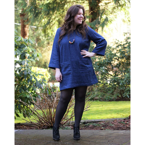 Helen wears a shift dress with patch pockets and bracelet-length sleeves.