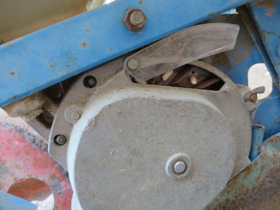 Détail d'un élément de semoir monograine avec quelques graines de haricots