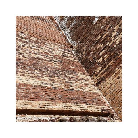 looking up an old brick wall. the old brick come in many different tones and shades and create some interesting patterns