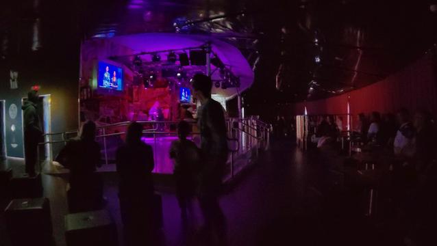 Eine Disko mit Leuten und dem Esc auf dem Fernseher
