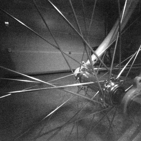 Closeup photograph of a bike wheel emphasizing the pattern of the spokes.