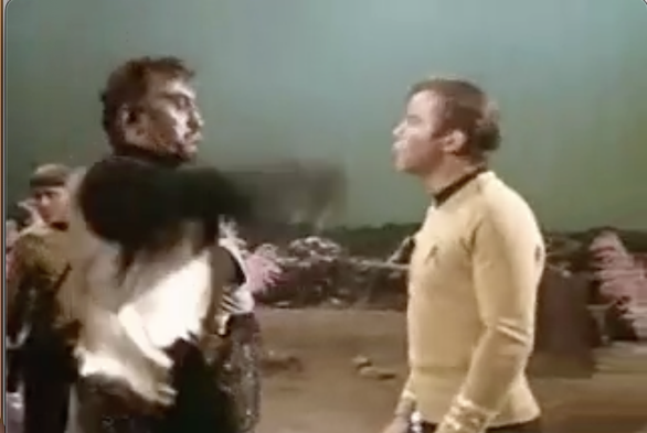 Stillframe from the Star Trek: Original Series episode Day of the Dove. The Klingon commander (left) swings his arm to slap Captain Kirk (right) and clearly misses him by 20 centimeters.