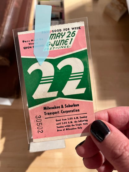 A vintage Milwaukee transit pass with a pink and green color palette