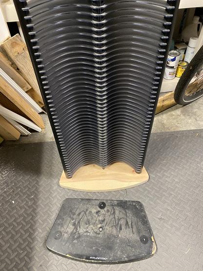 a tall double-columned CD rack attached to a new bare-wood base, the
previous pressboard and laminate base sitting on the floor in front of the new