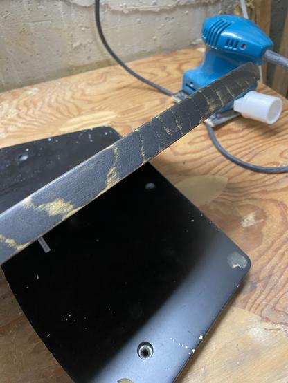 the front edge of the new baseplate with yellow stripes of woodgrain showing through the black base stain