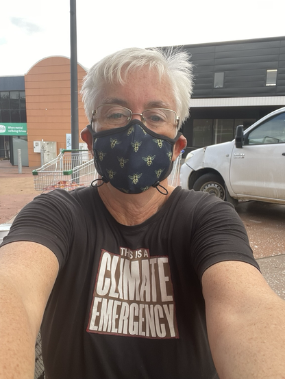 Masked woman wearing a This is a Climate Emergency tshirt