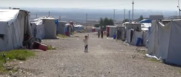 Un enfant au milieu d’un camp.