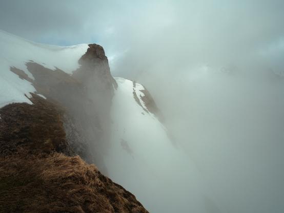 Mystical mountain landscape in the Swiss Alps. Peaks appear vaguely between clouds. Landscape photography with Fujifilm.
