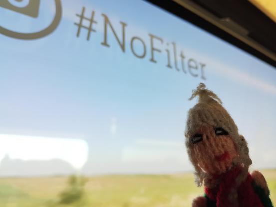 Puppet in front of a train window with the hashtag #NoFilter.