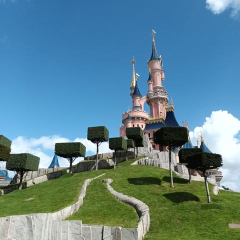 the castel in eurodisnzy, with trees insanely tortured as cubes. very blue sky. very green grass.