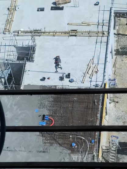 vu de haut, un gars allongé sur le sol du chantier qui fait la sieste