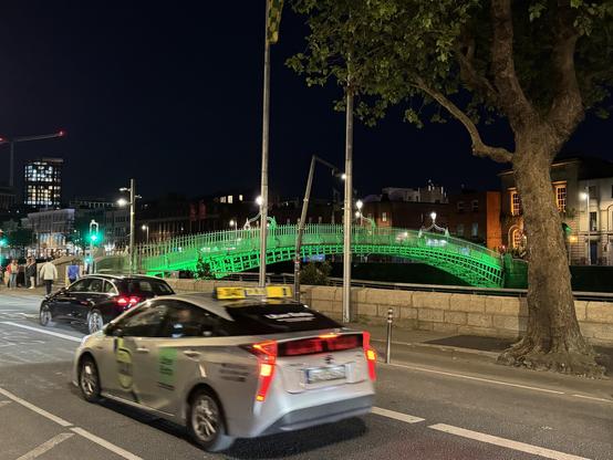 Bridge over the river in downtown Dublin, lit up in green.