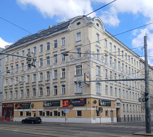 Eigene Fotografie eines viergeschossigen Eckgebäudes mit gelber Fassade. Hier war früher das Gut(t)enbergkino (Wien, 3., Rennweg 87, Ecke Oberzellergasse 22).