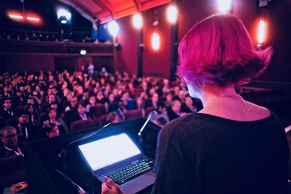 Jo Franchetti addressing FFConf in 2018 with amazingly bright pink hair and a completely captive audience.