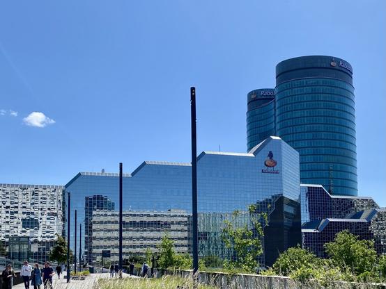 Blue Rabobank headquarters in the sun, reflecting the buildings next to it.